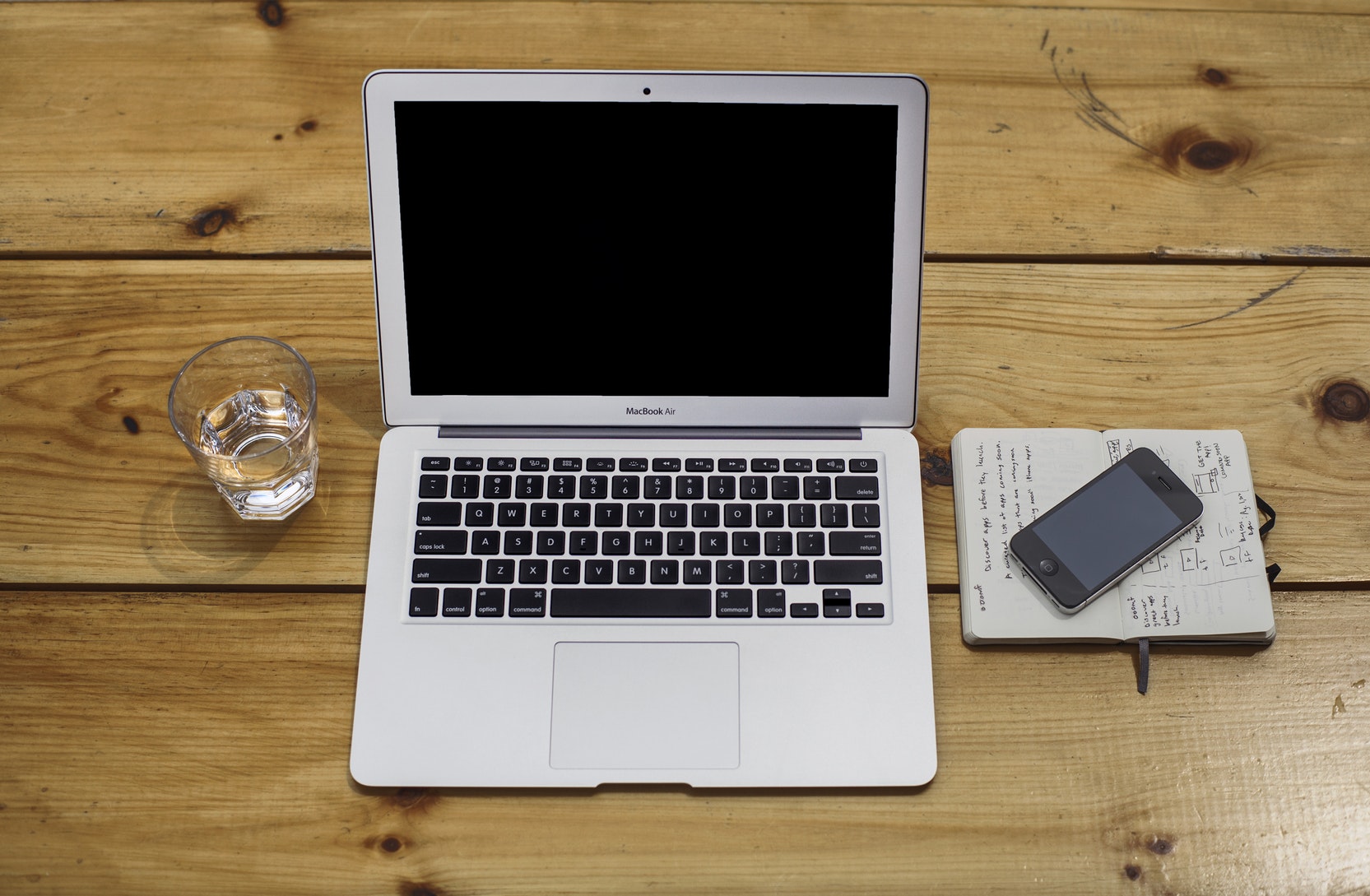 Ein Foto von einem MacBook und einem Iphone auf einem Schreibtisch
